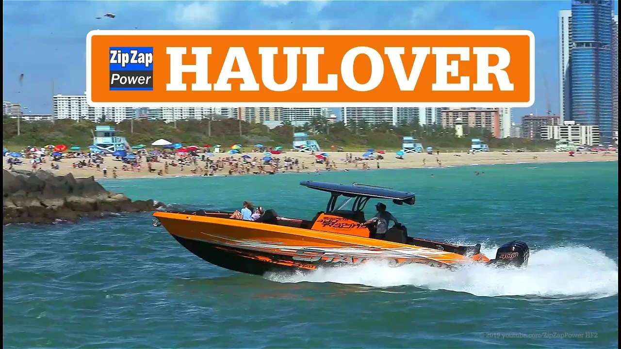 An Orange Center Console Boat coming into Haulover inlet with a crowded beach in the background